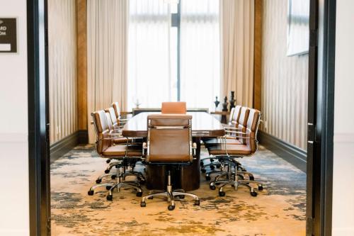 a conference room with a table and chairs at The Alamite, Tuscaloosa, a Tribute Portfolio Hotel in Tuscaloosa