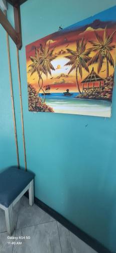 a painting of a beach with palm trees on a wall at Casa Mariner Resort in Good Hope