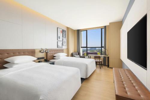 a hotel room with two beds and a flat screen tv at Four Points by Sheraton Ji’an in Ji'an