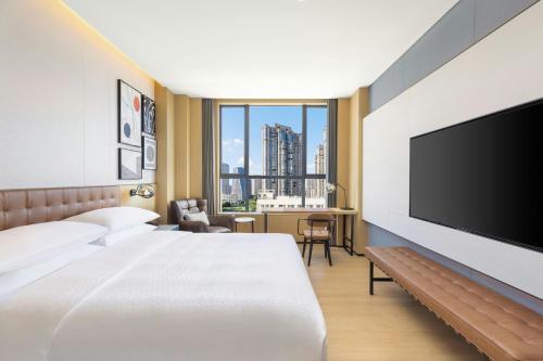a hotel room with a bed and a flat screen tv at Four Points by Sheraton Ji’an in Ji'an
