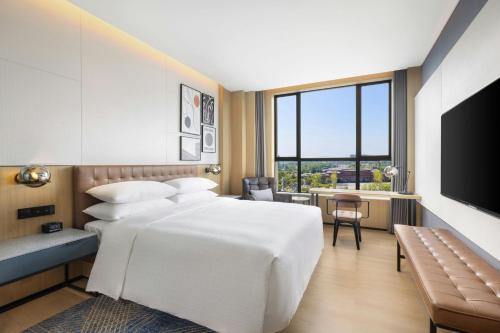 a hotel room with a bed and a television at Four Points by Sheraton Ji’an in Ji'an
