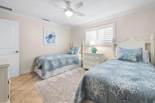 a bedroom with two beds and a ceiling fan at Sandpiper Beach 205 in Ybel
