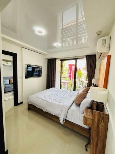 a bedroom with a large bed and a window at MBC Condotel Maikhao beach in Mai Khao Beach
