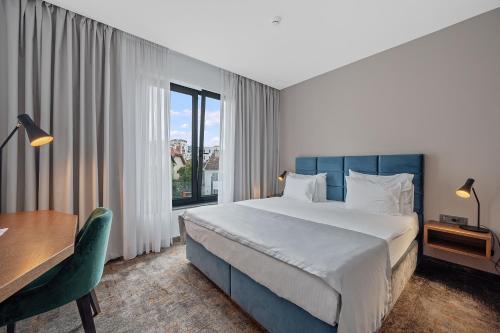 a bedroom with a bed and a desk and a window at iNova in Zagreb