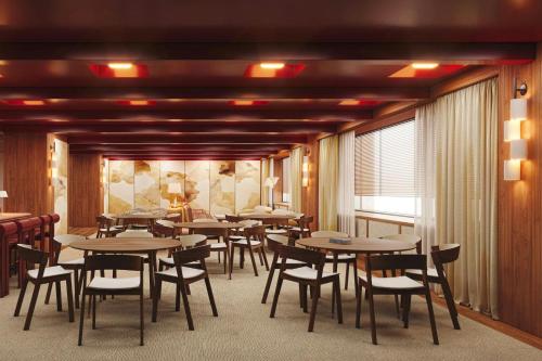 a dining room with tables and chairs and a window at Sheraton Stockholm Hotel in Stockholm