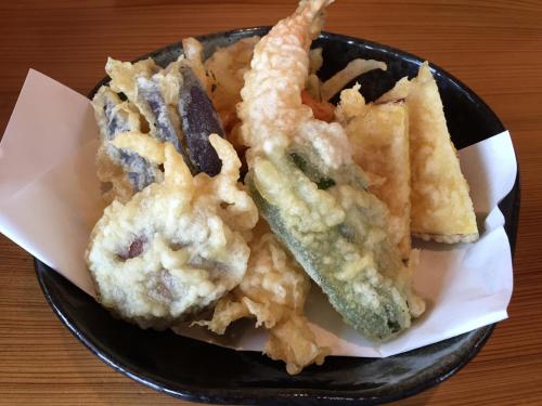a black bowl of food with some tempura at kinugawaonsen Fukumatsu in Nikko