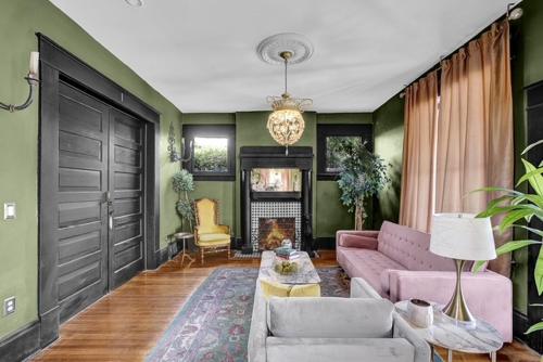 a living room with a pink couch and a fireplace at Historic Casa Mina 1BR Near Downtown w Parking in El Paso