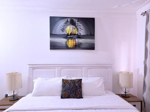 a bedroom with a white bed with two lamps at Munyonyo Haven in Kampala