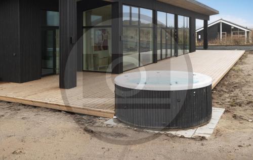 Un edificio con una terraza de madera con una mesa redonda. en Stunning Home In Spøttrup With Sauna, en Lem