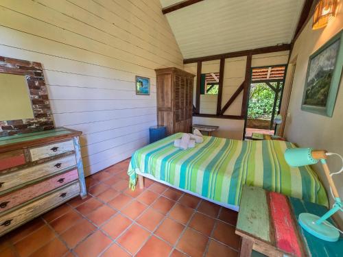a bedroom with a bed and a dresser in a room at La Case à Lucie in Saint-Pierre