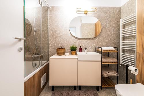 Maison Lumière - A modern Designer Apartment in Central Bucharest في بوخارست: حمام مع حوض ودش