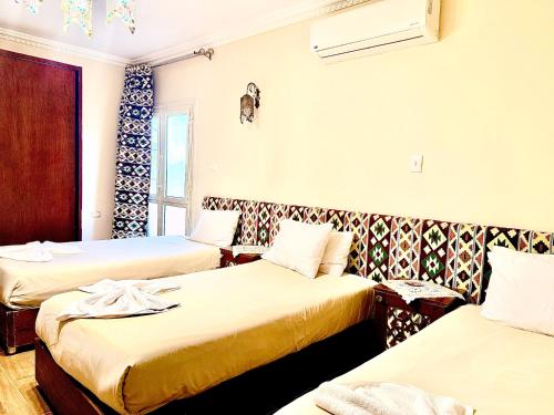 a hotel room with two beds and a window at Five Pyramids Peaks View in Cairo