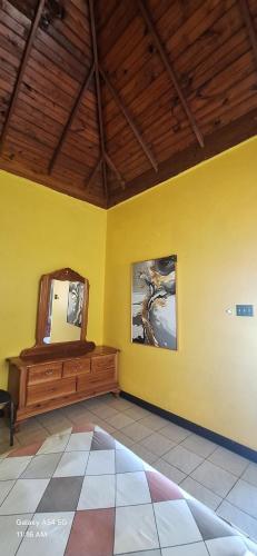 a room with a mirror and a yellow wall at Casa Mariner Resort in Good Hope