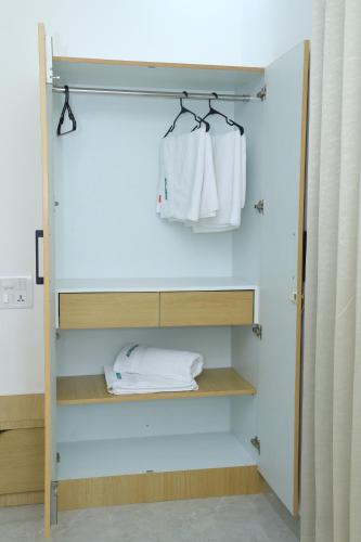 a bathroom with a closet with white towels at Hotel Aeroview Near Chennai Airport in Chennai