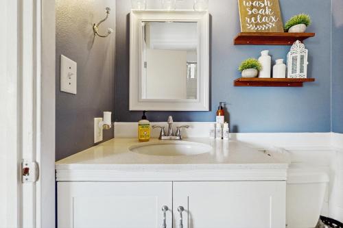 Un baño con un lavabo blanco y un espejo. en Kona Shores 229, en Kailua-Kona