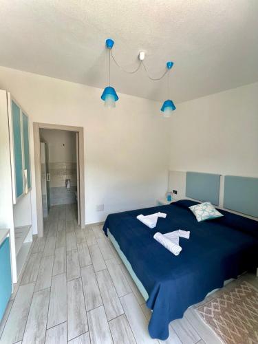 a bedroom with a blue bed with two towels on it at Hotel Pranos Turismo Rurale Cala Gonone in Cala Gonone