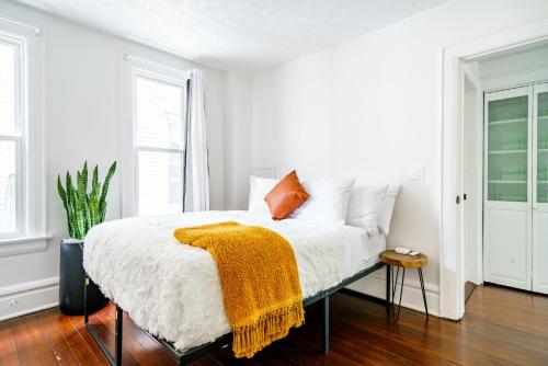 a bedroom with a bed with an orange blanket on it at Prime Location Top Rated Clean Parking Free! in Columbus