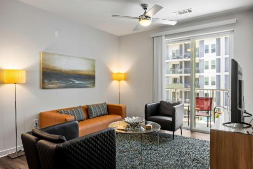 a living room with a couch and chairs and a tv at BCA Furnished Apartments in Atlanta