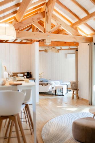 a living room with wooden ceilings and tables and chairs at Dolce et Cabane in Bérat