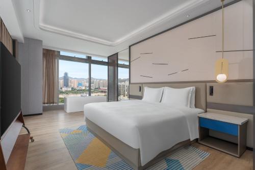 a bedroom with a white bed and a large window at Holiday Inn Express Lanzhou Downtown by IHG in Lanzhou