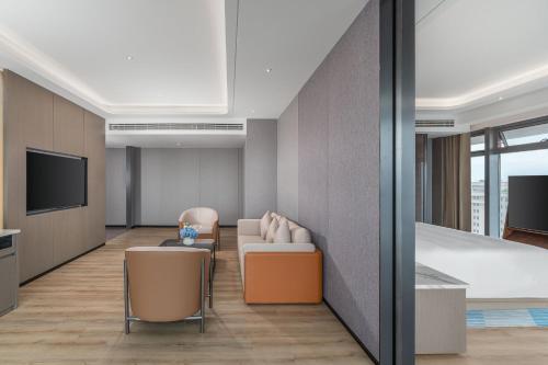 a living room with a couch and chairs and a tv at Holiday Inn Express Lanzhou Downtown by IHG in Lanzhou