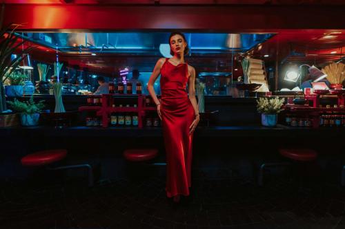 a woman in a red dress standing in a bar at W Abu Dhabi - Yas Island in Abu Dhabi