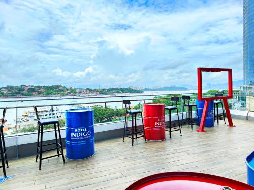 a balcony with bar stools and tables on a roof at Hotel Indigo Xiamen Harbour by IHG in Xiamen