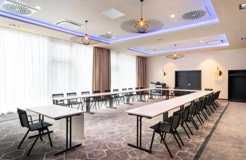 a large conference room with tables and chairs at Leonardo Royal Hotel Cologne Bonn Airport in Cologne