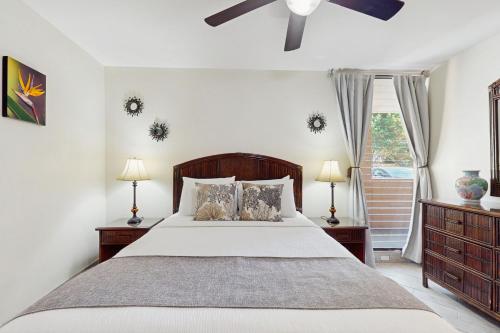 Un dormitorio con una cama y un ventilador de techo. en Paki Maui 112, en Honokowai
