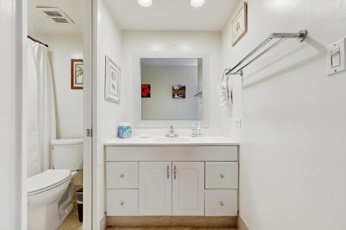 Un baño blanco con lavabo e inodoro. en Paki Maui 112, en Honokowai