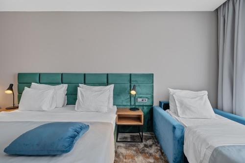 a hotel room with two beds with blue and white pillows at iNova in Zagreb