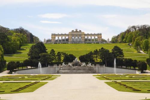 a large building with a fountain in front of a garden at NH Collection Wien Zentrum in Vienna