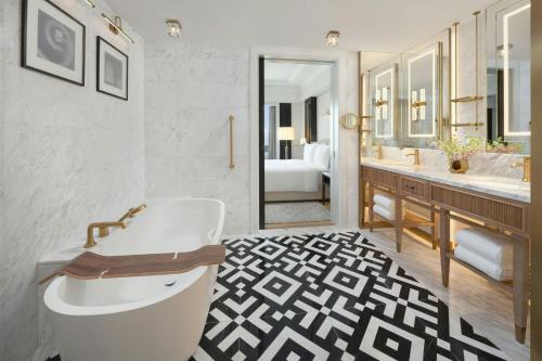 a bathroom with a white tub and a sink and a tub at The Laurus, a Luxury Collection Resort, Singapore in Singapore