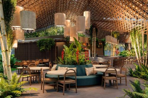 a restaurant with tables and chairs and plants at Santa Lucia Jungle Hacienda, Autograph Collection in Tarcoles