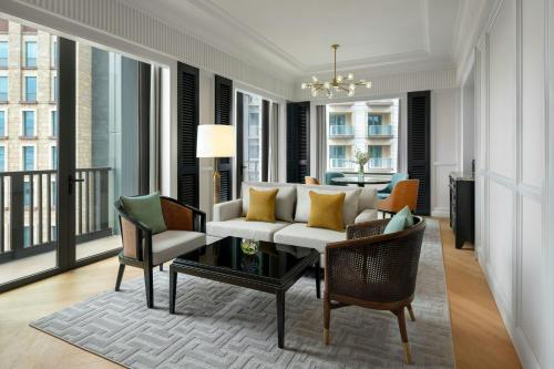 a living room with a white couch and chairs at The Laurus, a Luxury Collection Resort, Singapore in Singapore
