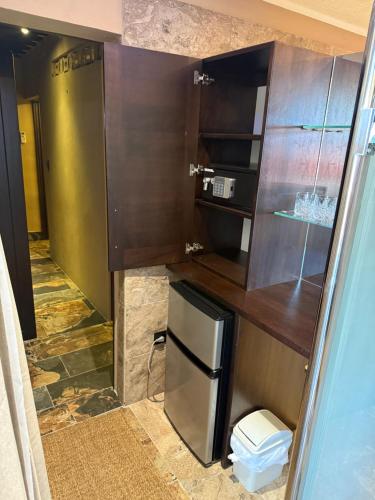 a small kitchen with a refrigerator in a room at Sosua Inn Hotel in Sosúa
