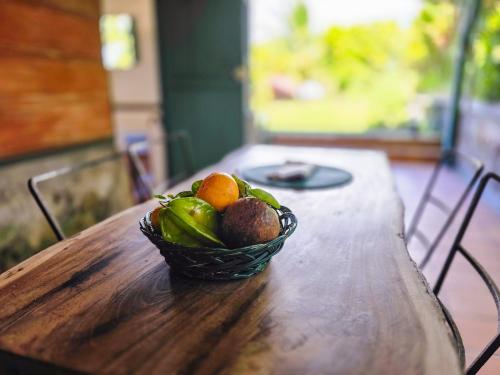 a basket of fruit sitting on a wooden table at La Boutique, case d'époque, vue Montagne Pelée in Saint-Pierre