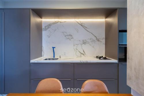 twee stoelen voor een keuken met een gootsteen bij Studio c/ churrasq. a 750m da UFSC - PST1409 in Florianópolis