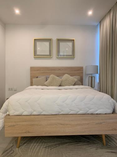 a bedroom with a large bed with a wooden frame at Real Escal 1 bedroom at Airport Residential in Accra
