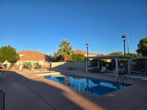 a swimming pool with tables and chairs in a yard at Mesquite Nevada Vacation Rental - Ground Level and double car garage in Mesquite
