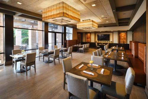a dining room with tables and chairs in a restaurant at Hotel Indigo East End by IHG in Riverhead