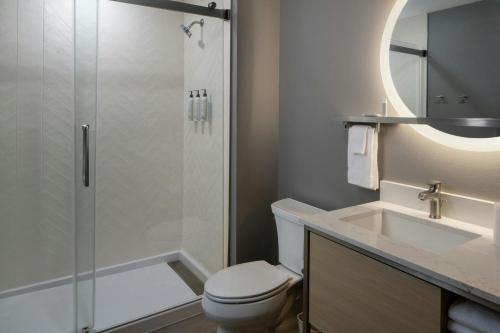 a bathroom with a toilet and a sink and a shower at TownePlace Suites Surprise Prasada in Surprise