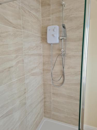 a shower with a shower head in a bathroom at Super king bed room A in Sherborne Saint John