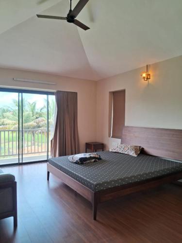 ein Schlafzimmer mit einem Bett und einem Deckenventilator in der Unterkunft Kalhaar Blues And Greens Premium Villa in Ahmedabad