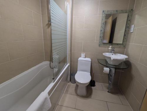 a bathroom with a toilet and a sink and a tub at AA Newcastle Apartments in Newcastle upon Tyne