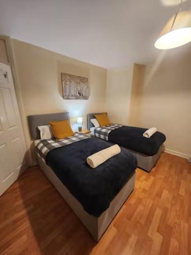 2 camas en una habitación con suelo de madera en Comfy 3-Bed House - Sleeps 6 & Free Parking, en Tilbury