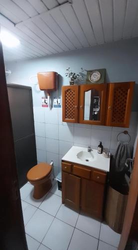 a small bathroom with a toilet and a sink at Recanto sem Saída in Paranaguá