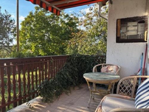 a patio with a table and chairs on a balcony at A Festő Vendégháza / The Painter's Guest House in Zánka