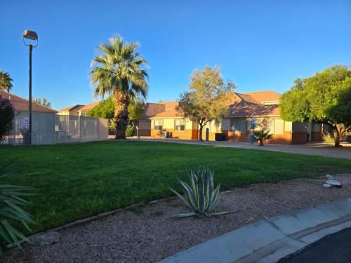 a yard with a green lawn with houses at Mesquite Nevada Vacation Rental - Ground Level and double car garage in Mesquite