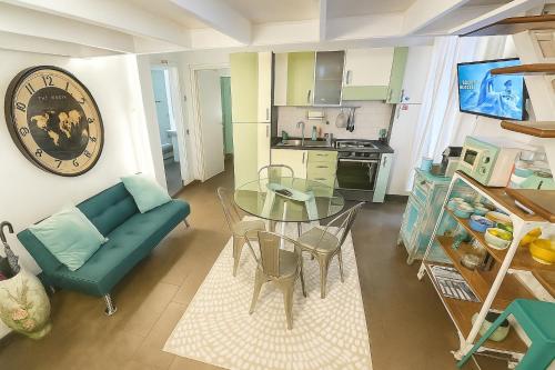 Una sala de estar con un sofá azul y una mesa de cristal. en Trastevere Stars, en Roma